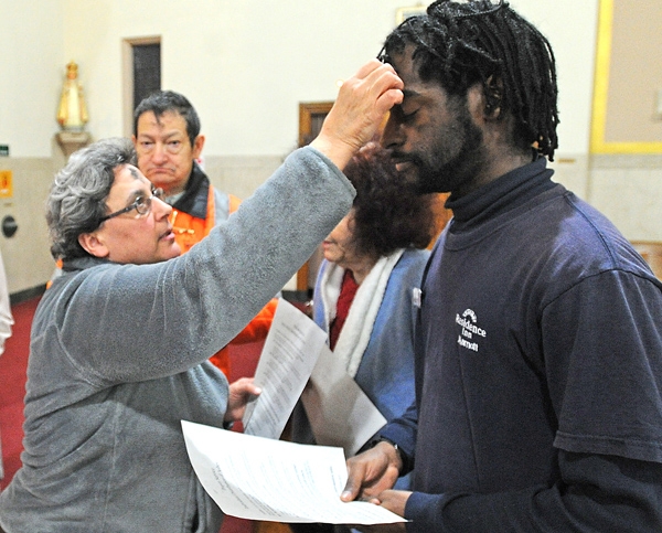 Eucharistic Minister JoAnn Mercurio gives ashes to Lance Waithe of Amherst Wednesday evening during the 15 hours of ashes at St. Benedict Church on Main Street in Amherst. (Dan Cappellazzo/Staff Photographer)